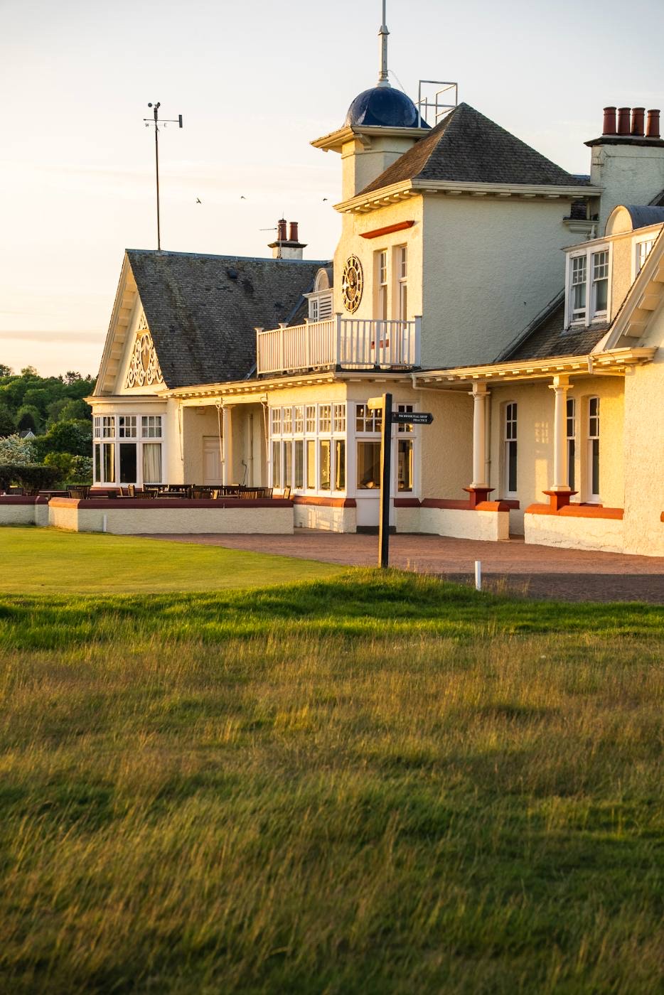 Vertical composition of the clubhouse tower, clock and gable detail with the terrace below