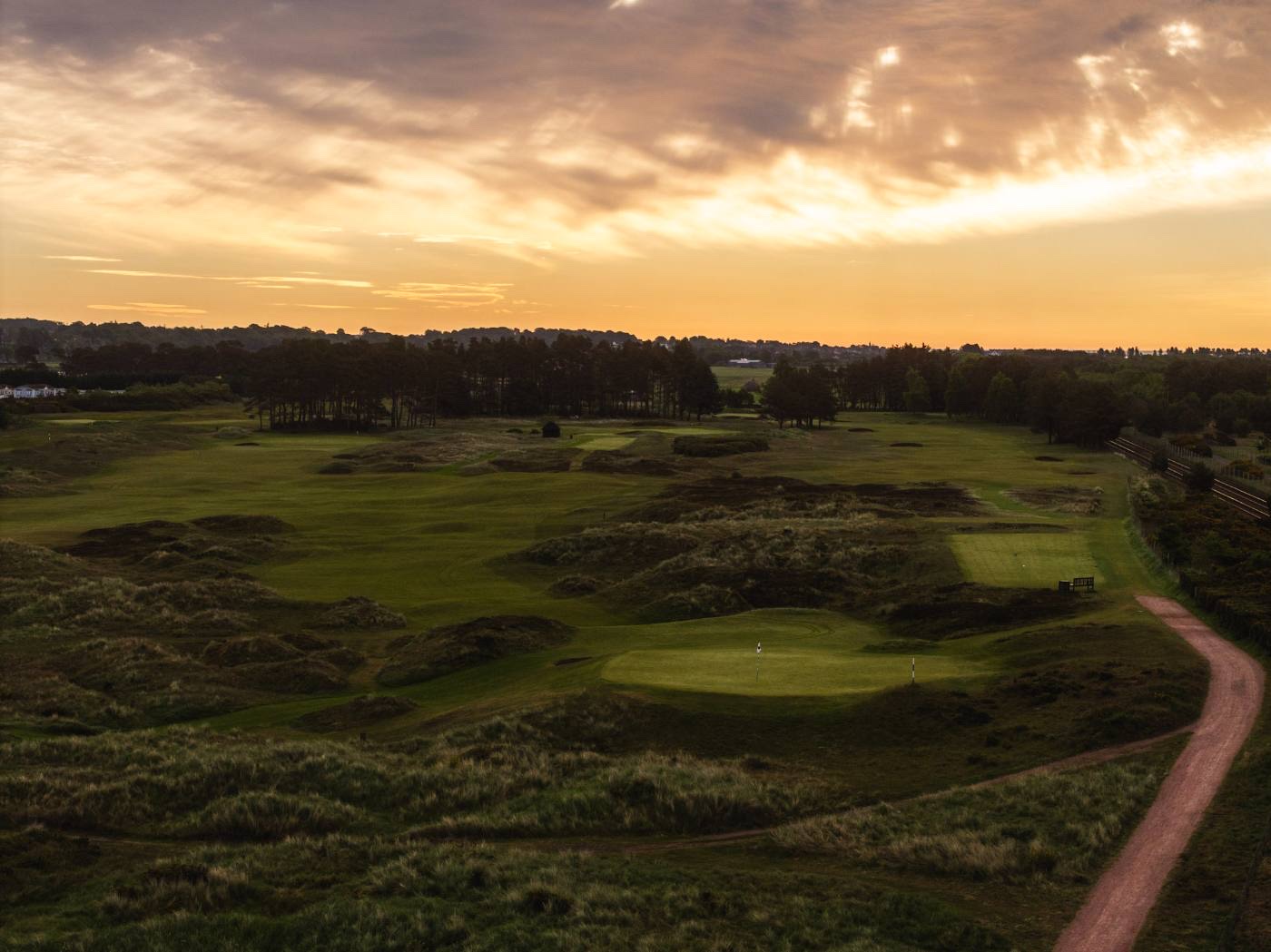 Aerial view of the links at morning, the track curving through the dunes