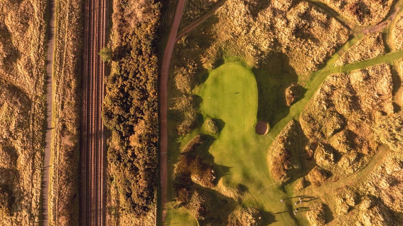 Overhead view of a green with the railway line running hard along its edge