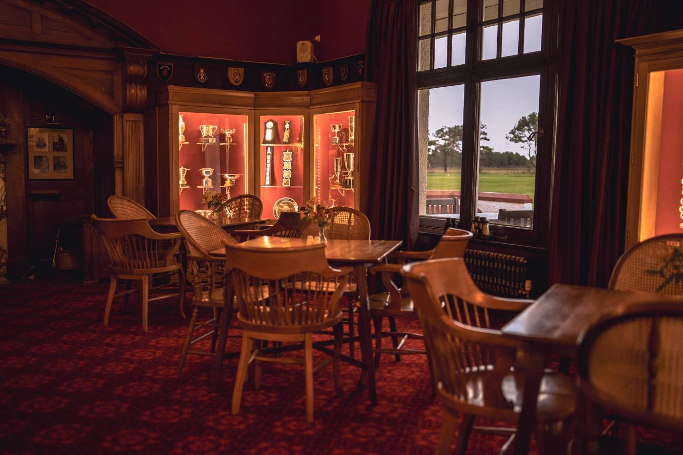 The trophy cabinet in the Hogan Lounge, silverware on red-backed shelving