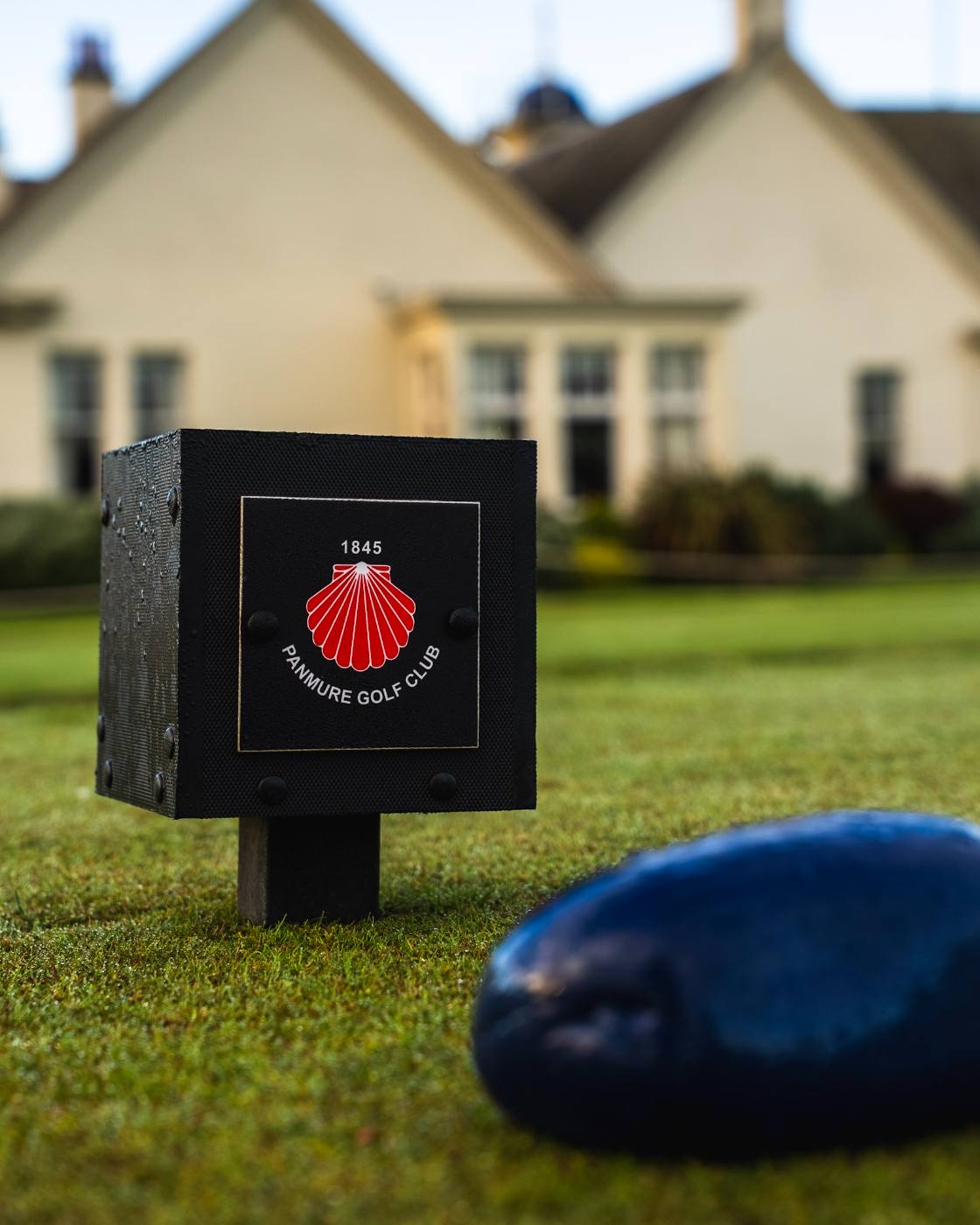 A black stone tee marker carrying the 1845 shell crest